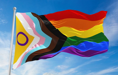 Image of a progressive pride flag flowing in the wind